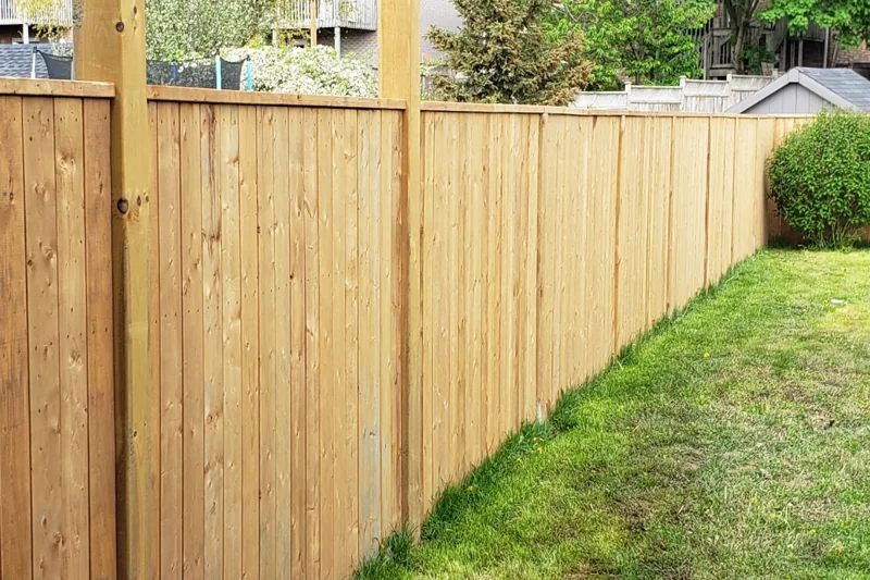 Wood privacy fence with vertical boards and supporting posts